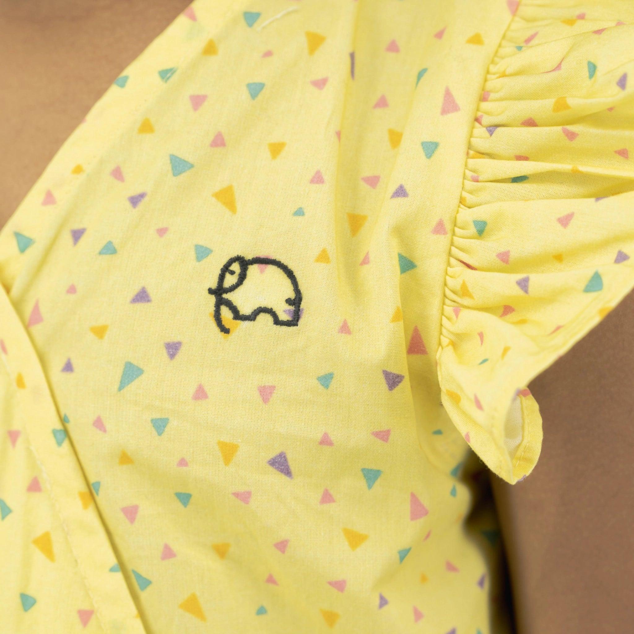 Close-up of a Lemon Meringue Cotton V-Neck Jumpsuit for Girls with a small car design and colorful triangle patterns by Karee.