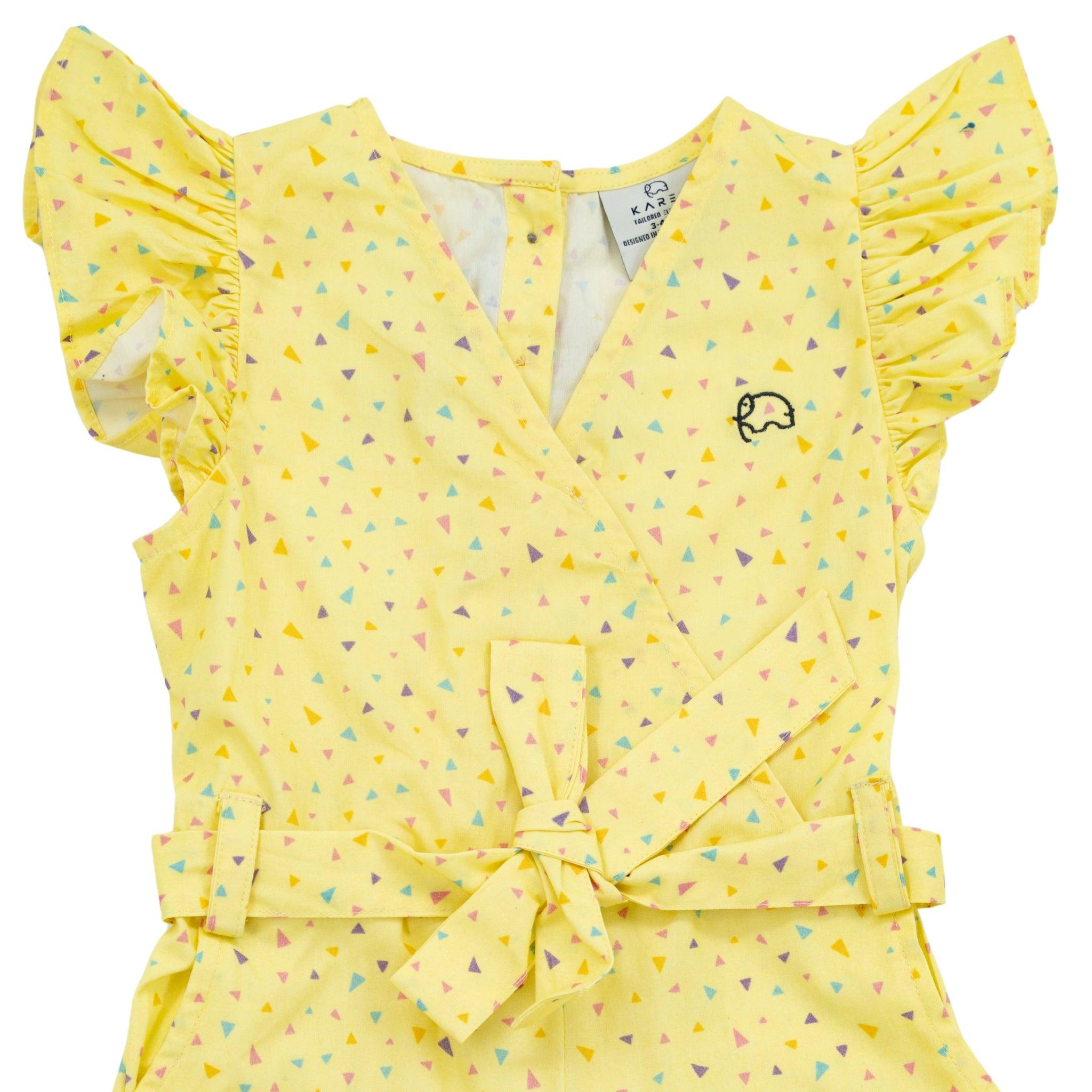 Yellow Lemon Meringue Cotton V-Neck Jumpsuit for Girls with ruffled sleeves and a geometric pattern, featuring a bow at the waist and a small elephant emblem. This piece is part of Karee's eco-conscious fashion line.