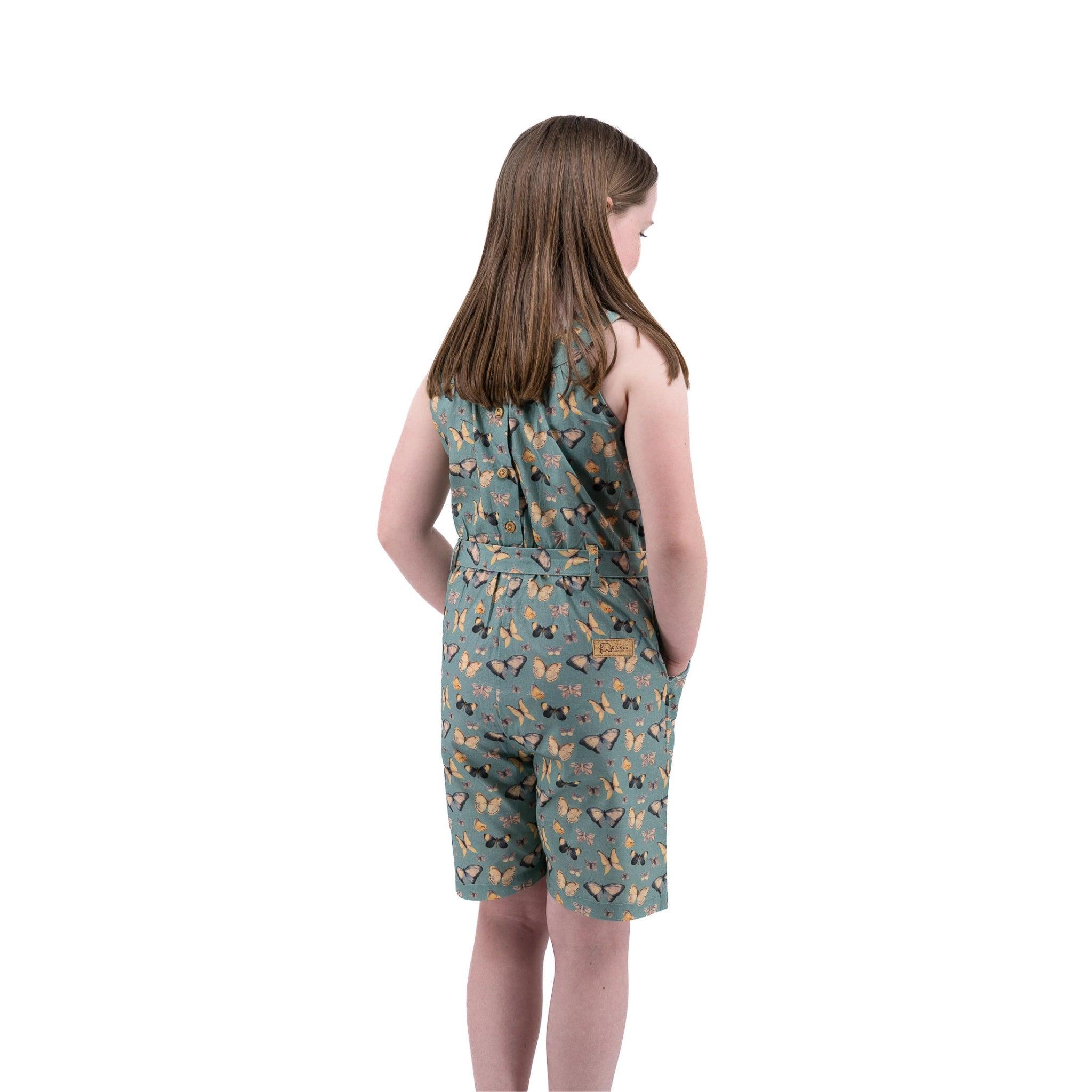 Young woman in a Karee Blue Surf Adventure-ready Cotton Play Suit standing sideways against a white background.